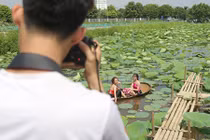Thiếu nữ đánh đổi làn da trắng, lội hồ sen chụp ảnh dưới nắng
