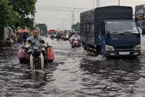 Mưa trái mùa, người dân TP HCM bì bõm trong nước ngập