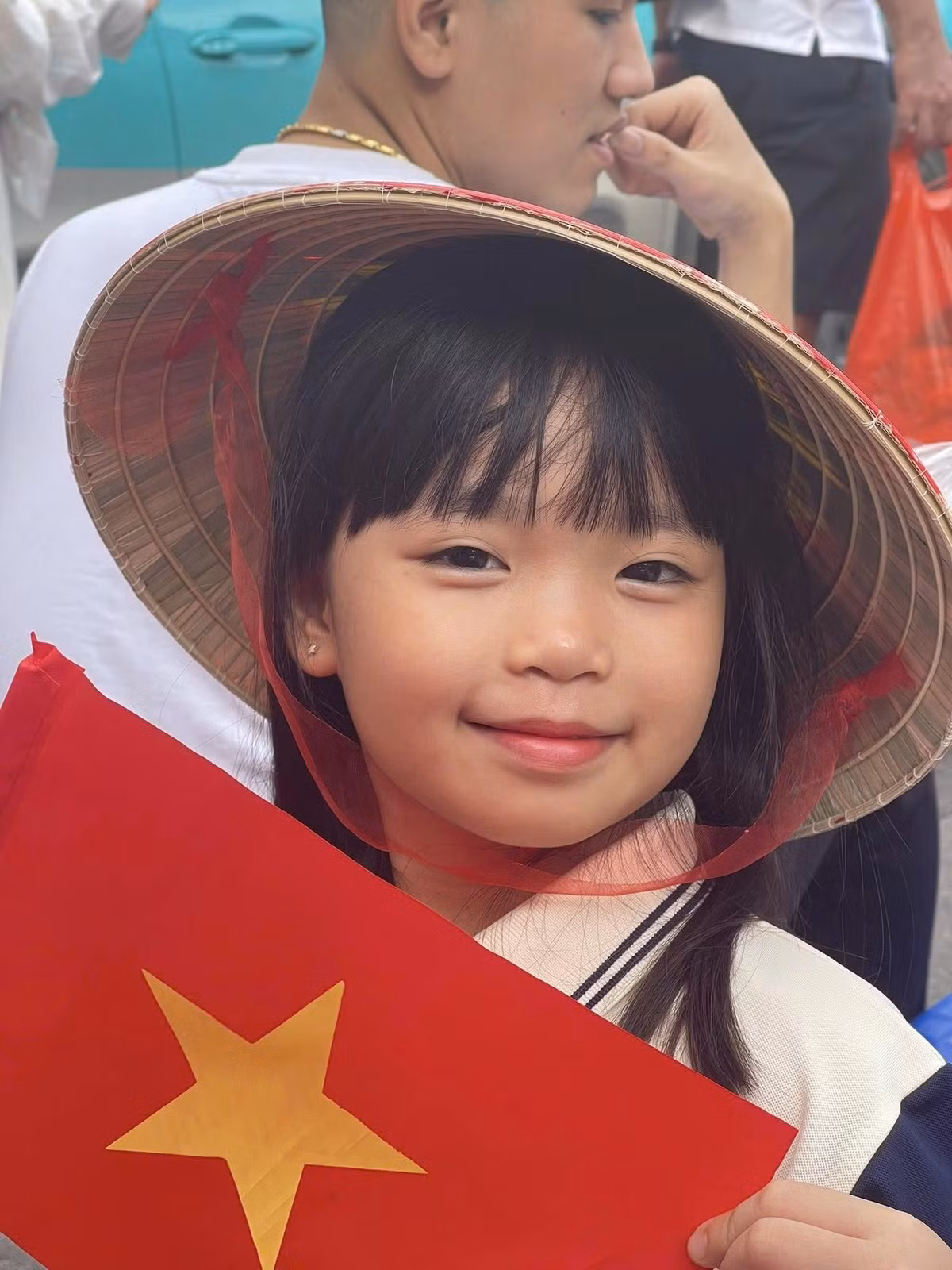 Bé gái hào hứng chờ đợi xem diễu binh, diễu hành.