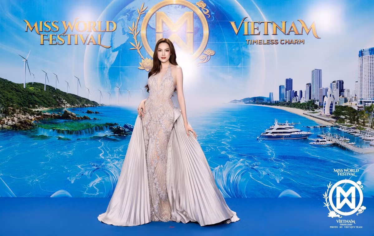Hoa hậu Lê Hoàng Phương xuất hiện với váy dạ hội tông nude đính kết, thiết kế cổ yếm và ôm sát vóc dáng. Hai dải vải xếp ly lớn ở hai bên tạo điểm nhấn cho trang phục. Cô để tóc dài uốn nhẹ, buông lệch một bên vai.
