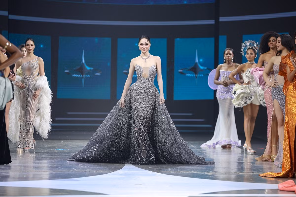 Khoảnh khắc xuất hiện với đầm dạ hội đính kết dày đặc giúp Hương Giang trở thành tâm điểm sân khấu. Thiết kế corset ôm sát phần thân trên kết hợp chân váy xòe lớn tạo hình ảnh như “nữ hoàng ngân hà”. Kiểu tóc vuốt gọn cùng lọn tóc uốn trước trán giúp tổng thể mang hơi thở điện ảnh cổ điển.