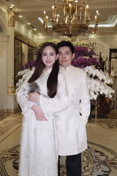 Vợ chồng Hương Liên thực hiện bộ ảnh gia đình trong không gian sang trọng. Người đẹp diện áo dài trắng nền nã, trong khi ông xã xuất hiện lịch lãm. Thú cưng cũng góp mặt như một thành viên đặc biệt của gia đình. Ảnh: Instagram Hương Liên.