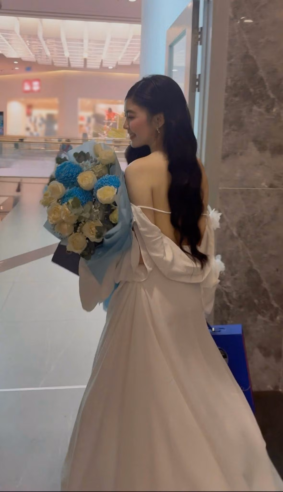 Váy trắng hở lưng với chi tiết nơ lớn phía sau cho thấy lựa chọn thời trang gợi cảm của Lọ Lem. Cô để tóc đen dài buông tự nhiên, hạn chế trang sức. Lối trang điểm nhẹ cùng làn da sáng giúp tổng thể vẫn giữ nét trẻ trung. (Ảnh: FB Mai Thảo Linh)