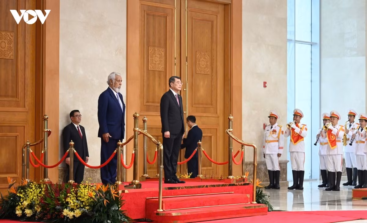 Thủ tướng Lê Minh Hưng và Thủ tướng Timor-Leste Kay Rala Xanana Gusmão đứng trên bục danh dự. Quân nhạc cả Quốc thiều hai nước