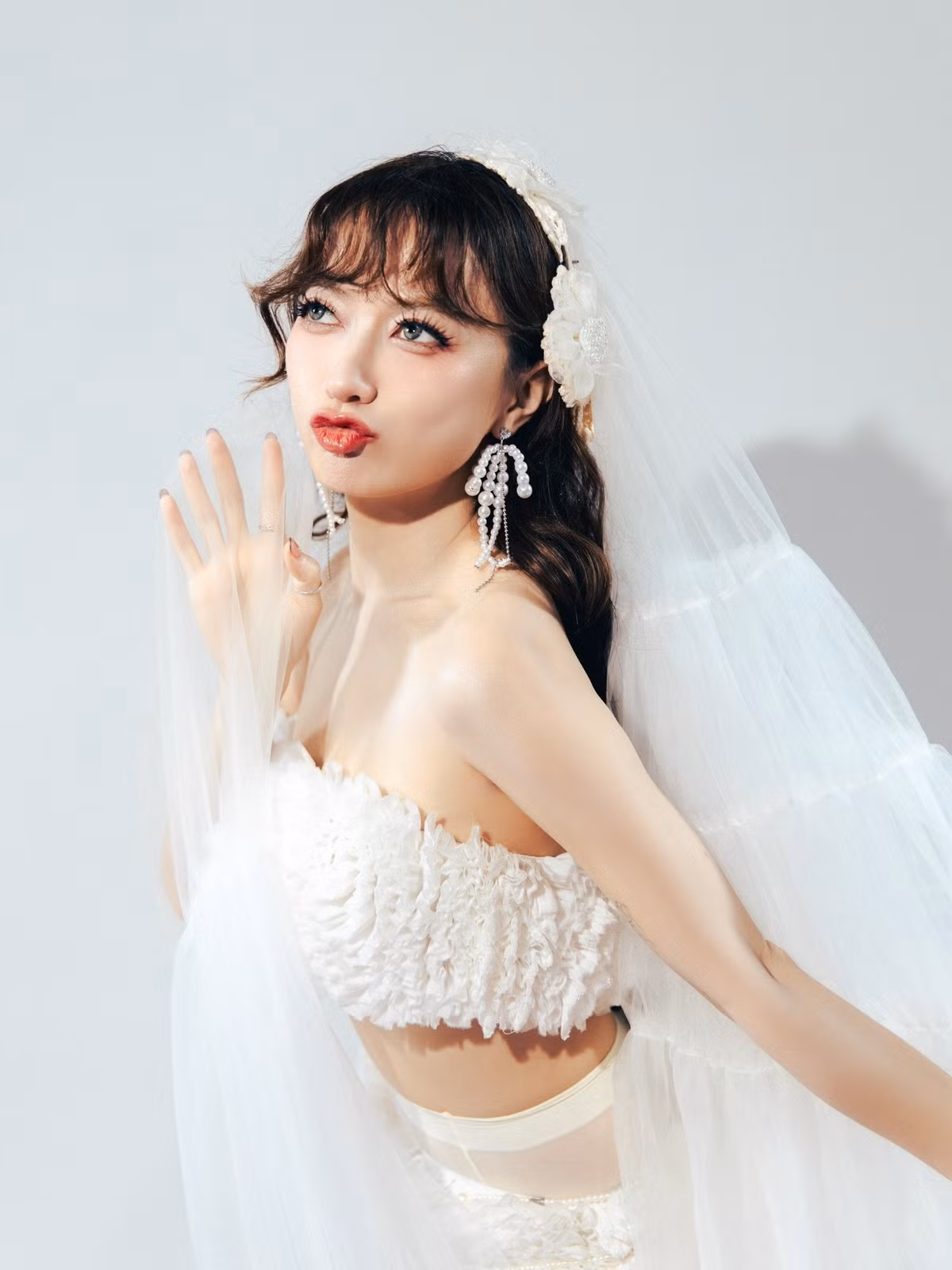 Trong bộ ảnh, Xuân Nghi chọn thiết kế cô dâu phá cách với áo cúp ngực chất liệu xếp tầng, chân váy ngắn phối voan dài quét sàn.