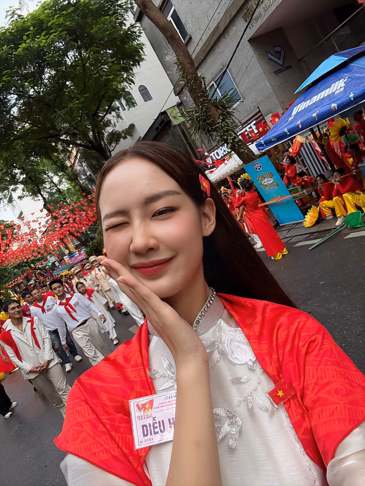 Hoa hậu Lê Nguyễn Bảo Ngọc diện áo dài trắng, khoác khăn quàng đỏ trên vai đến tham gia buổi tổng duyệt A80. Ảnh: Sen Vàng.