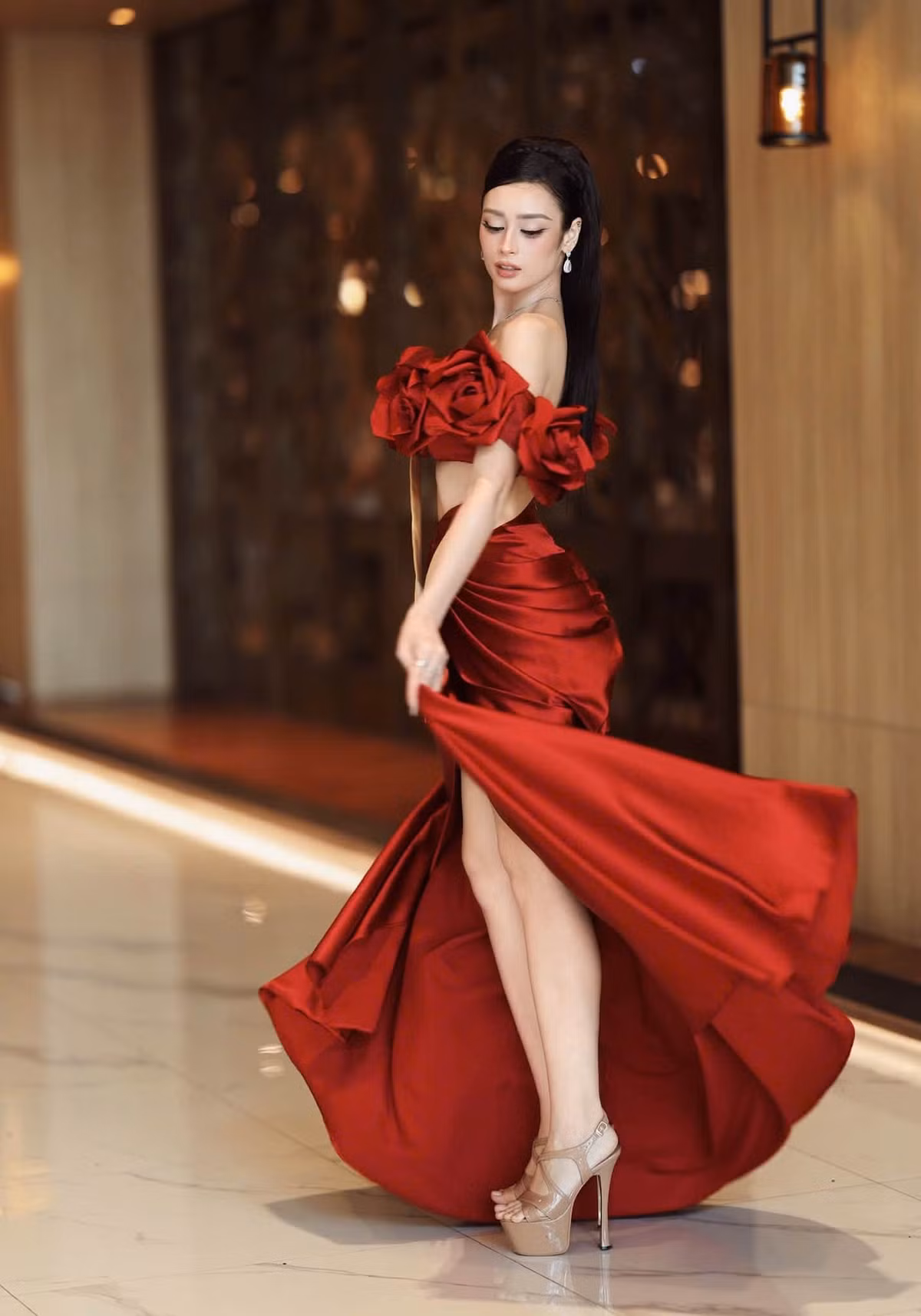 Người đẹp thay đổi phong cách qua nhiều trang phục, từ thiết kế tông cam đến váy đỏ trễ vai, xẻ cao. Ảnh: FB Emoura Phạm.