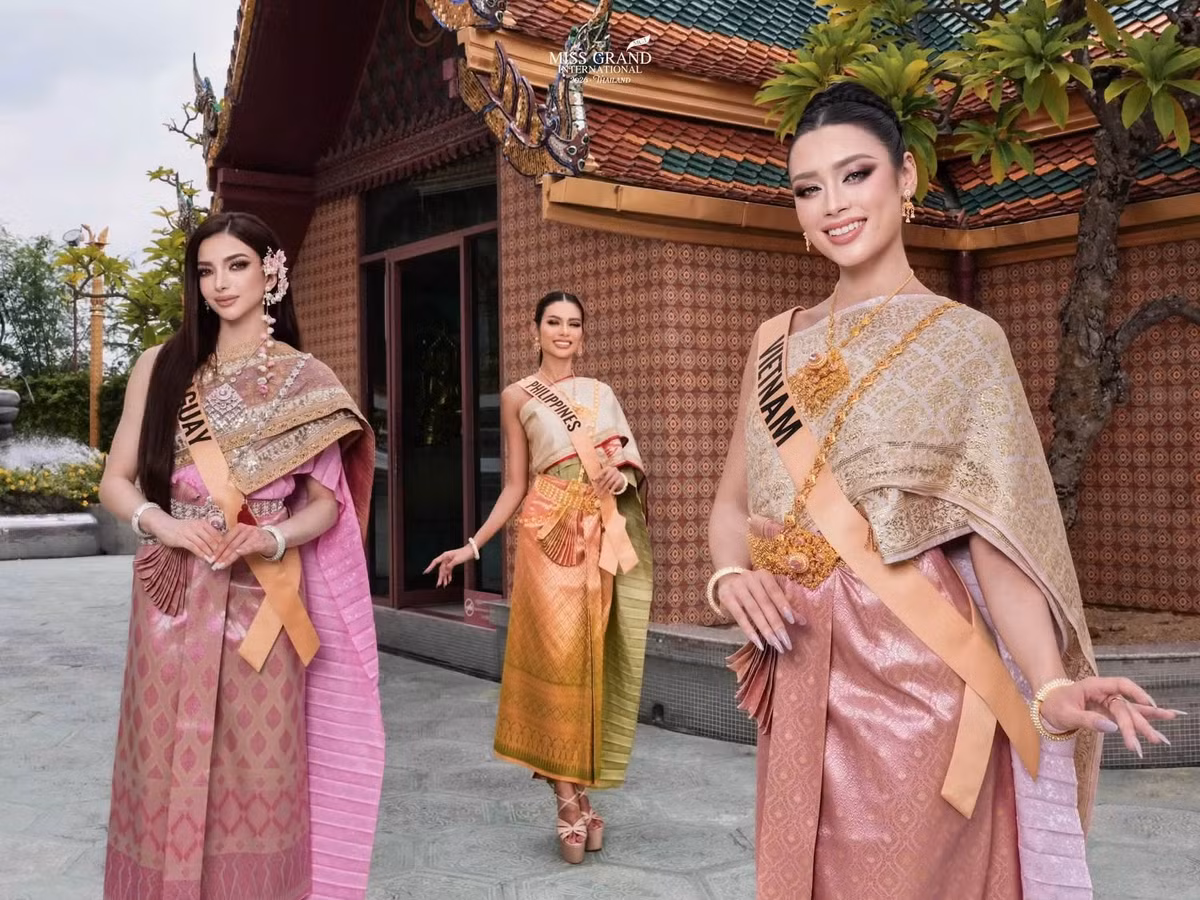Emoura Phạm tham gia hoạt động cùng các thí sinh quốc tế trong trang phục truyền thống Thái Lan. Đại diện Việt Nam xuất hiện bên người đẹp Guam và Philippines trong một lịch trình của Miss Grand International 2026. Ảnh: FB Emoura Phạm.