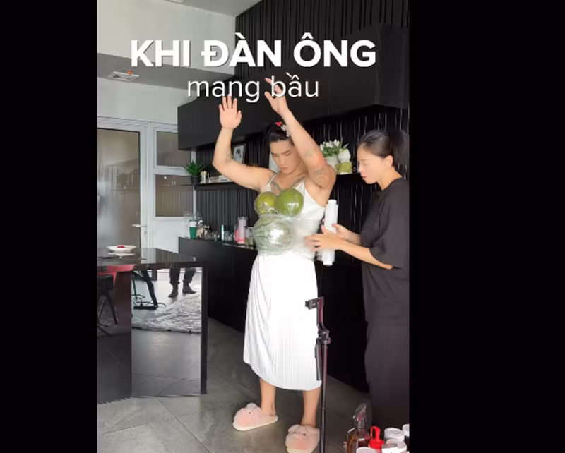 Ngô Thanh Vân giúp Huy Trần mang trái cây trên ngực và bụng để thử nghiệm cảm giác mang bụng bầu vượt mặt. Ảnh: FB Huy Trần.