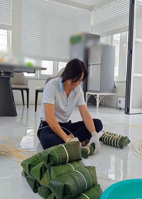 Hoài Phương bày tỏ sự xúc động khi đón tuổi mới đúng dịp Tết. Anh cho biết đây là lần đầu tự tay gói bánh tét. “Nay sinh nhật mình, ngay dịp Tết được cô tổ chức gói bánh thấy ấm áp. Lần đầu mình gói được bánh tét. Áo hồng kế bên gói được luôn đấy mà không biết vớt ra sẽ thế nào. Đợi thành phẩm các bác nhé”, nam nhạc sĩ viết. Ảnh: FB Việt Hương.