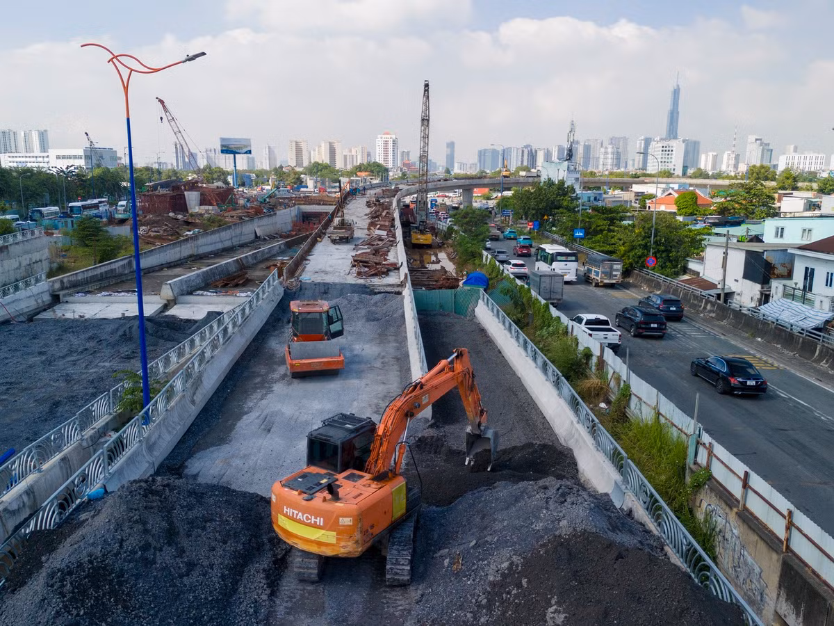 Phần đường dẫn lên cầu đang được nhà thầu cấp phối đá dăm, chuẩn bị thảm nhựa.