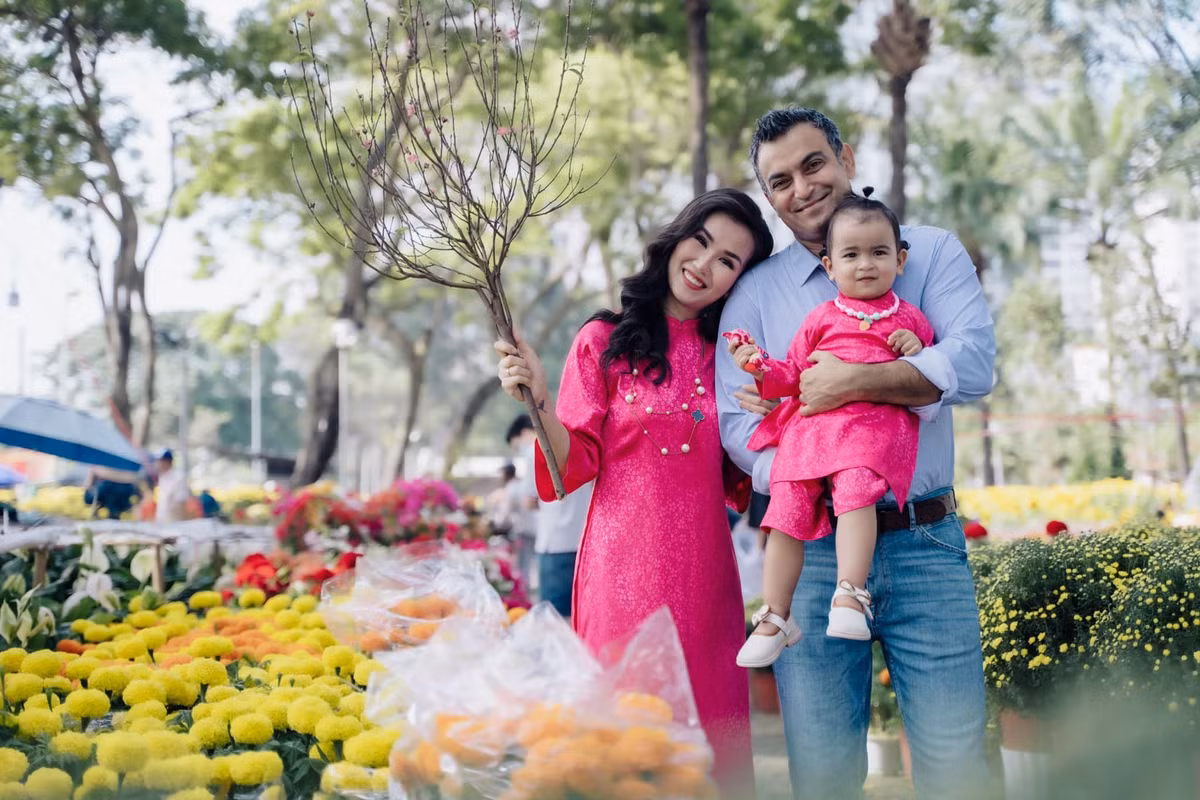 Doanh nhân Vikas Chaudhary ngại không dám nhận lì xì vì chưa hiểu về tập tục của người Việt. Võ Hạ Trâm giải thích với chồng lì xì là điều may mắn, lời chúc tốt đẹp, suôn sẻ trong năm mới. Ảnh: FB Võ Hạ Trâm.