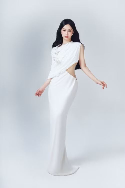 Thiết kế trắng cắt xẻ giúp tôn tỷ lệ cơ thể cân đối của người đẹp. Bên cạnh hoạt động nghệ thuật, Jun Vũ còn là gương mặt quen thuộc trong nhiều chiến dịch quảng cáo và sự kiện thời trang.