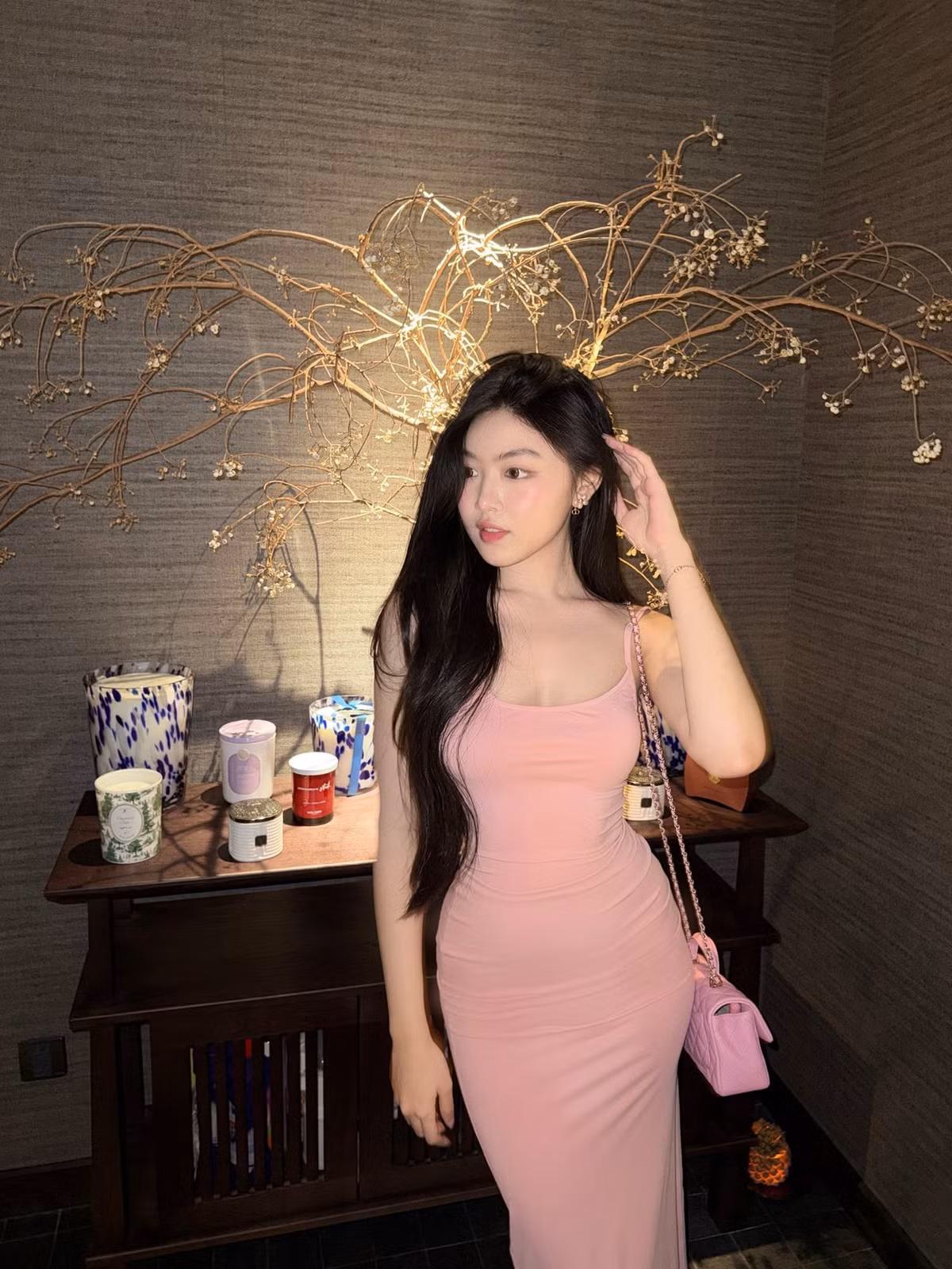 Với váy hai dây hồng ôm dáng, Lọ Lem phối túi mini cùng tông, tạo tổng thể đơn sắc. Phom váy tôn vóc dáng, còn mái tóc dài gần như không tạo kiểu cầu kỳ giúp gương mặt trở thành điểm chú ý. Cô tiếp tục ưu tiên lối trang điểm tự nhiên. (Ảnh: FB Mai Thảo Linh)