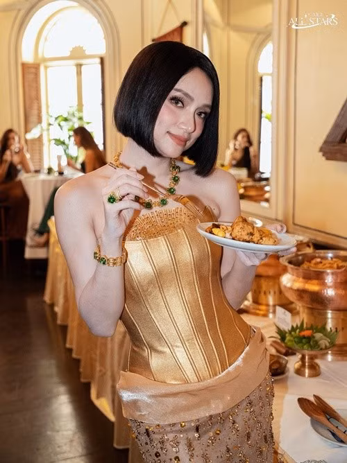 Hương Giang tạo dáng bên bàn tiệc với thần thái nhẹ nhàng nhưng vẫn giữ được vẻ sang trọng. Bộ trang sức trở thành điểm nhấn giúp tổng thể thêm nổi bật. Ảnh: Miss Grand International.