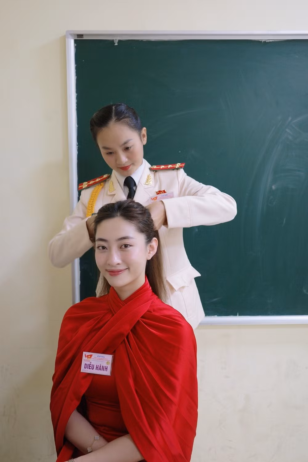 Lương Thùy Linh được nữ chiến sĩ cảnh sát thắt tóc trước giờ tổng duyệt. Ảnh: Sen Vàng.