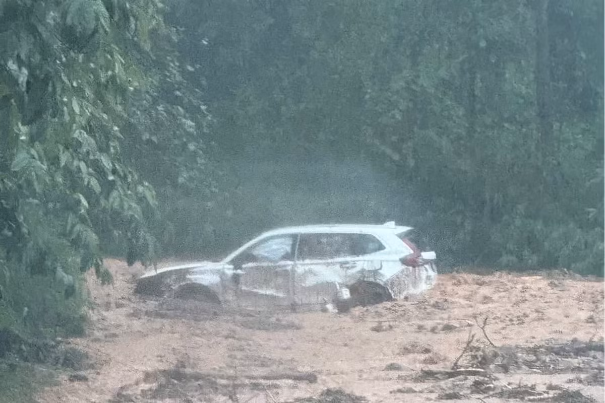 Chiếc xe chở hai vợ chồng và cháu nhỏ bị đất, đá vùi lấp nửa thân xe, may mắn không bị thiệt hại về người