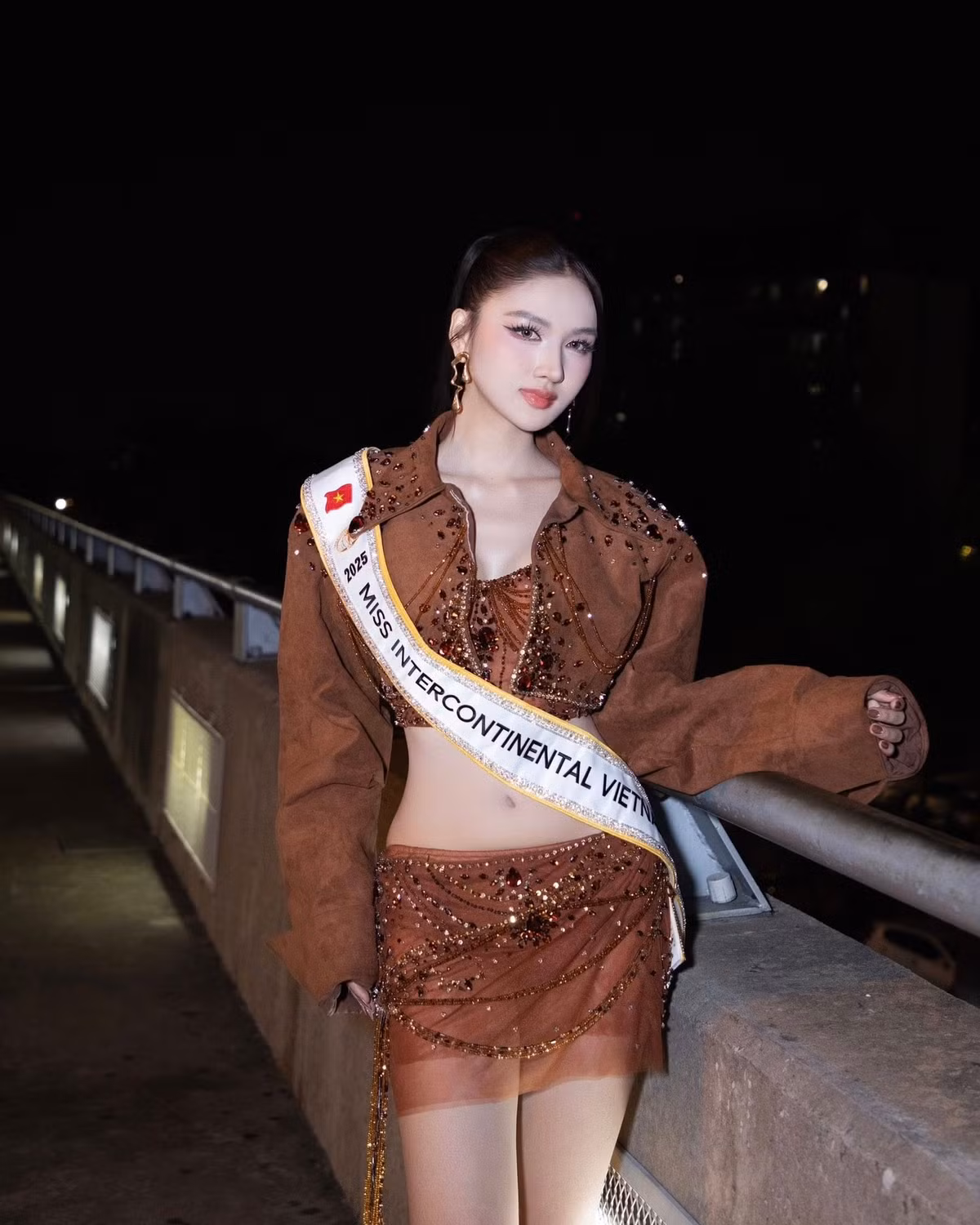 Á hậu Thu Ngân vừa khởi hành sang Ai Cập, bắt đầu hành trình tham gia cuộc thi nhan sắc quốc tế Miss Intercontinental - Hoa hậu Liên lục địa. Tại sân bay, cô diện bộ trang phục hai mảnh tông nâu ánh đồng. Thiết kế ôm sát tôn lên vòng hai con kiến, đôi chân dài thon gọn.