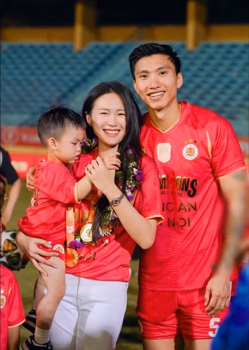 Theo Znews, Doãn Hải My có mặt trên sân Hàng Đẫy để chung vui cùng Đoàn Văn Hậu trong ngày CAHN nâng cúp vô địch V.League 2025/26. Người đẹp diện áo đấu của đội bóng, bế con trai Lúa và rạng rỡ bên chồng sau trận đấu. Ảnh: FB Đoàn Văn Hậu.