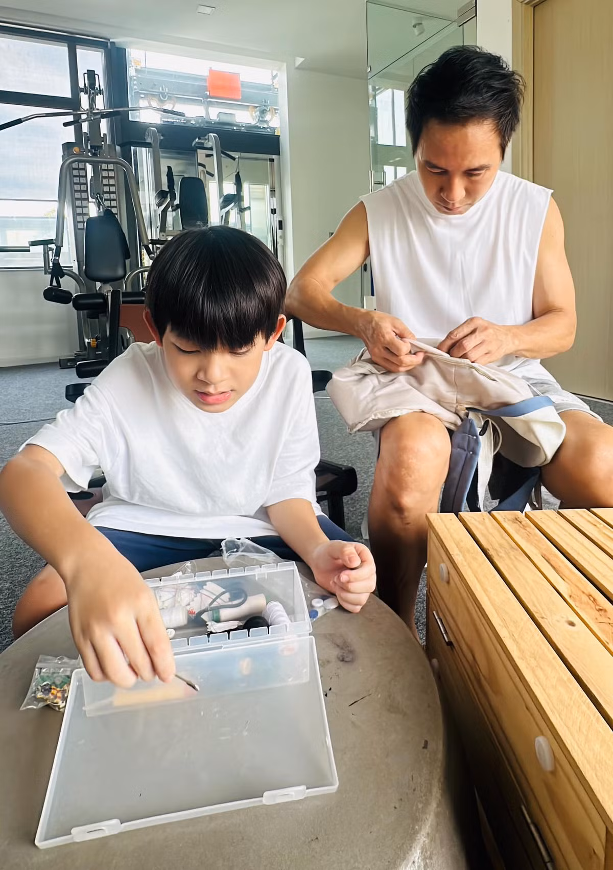 Minh Hà ghi lại khoảnh khắc ông xã Lý Hải cặm cụi sửa cặp cho con trai. Ảnh: FB Ly Hai Minh Ha