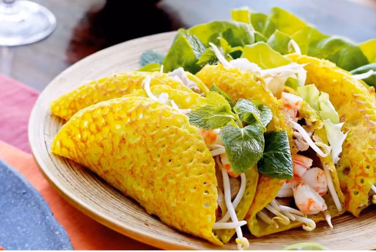 Nếu lần đầu đến Huế, du khách dễ nhầm bánh khoái thành bánh xèo vì hình thức bên ngoài. Nếu nhìn kỹ bạn sẽ thấy lớp vỏ bột của bánh khoái nhỏ, dày và giòn hơn bánh xèo. Nước chấm của bánh khoái được gọi là “nước lèo” gồm các thành phần gan heo, thịt nạc băm nhuyễn, mè rang, đậu phộng giã nhuyễn cùng nước tương đậu nành Huế chính gốc. Ảnh: Traveloka