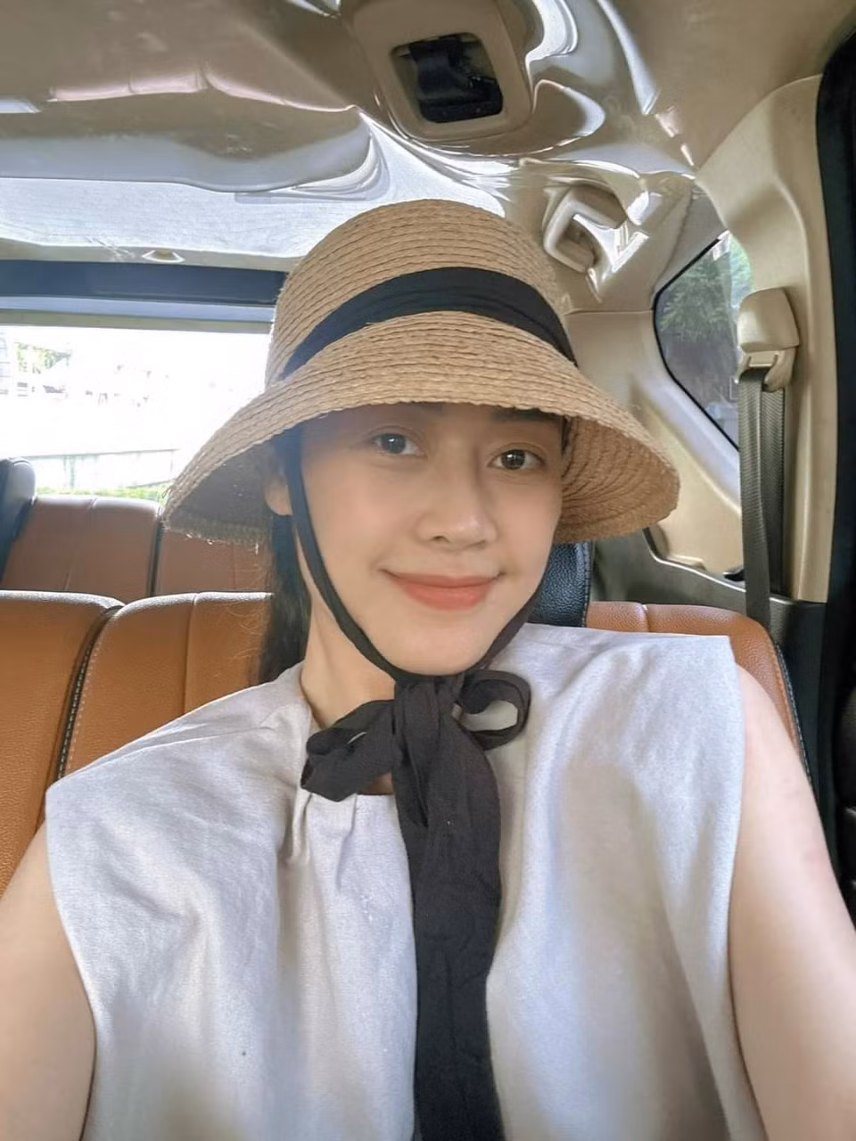 Ngồi ô tô nhưng MC Phí Linh vẫn đội mũ để tránh nắng.