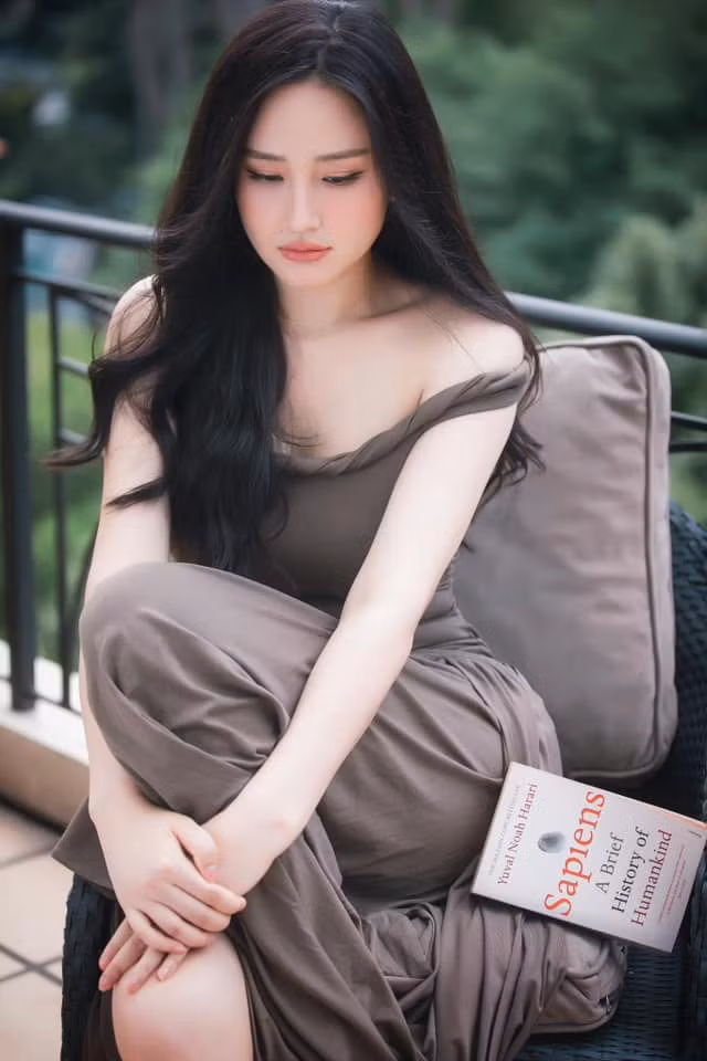 "Em tôi quơ đại một quyển trên giá sách nhà tôi bảo chị cầm đọc với vẻ thơ thơ đi để chụp", Hoa hậu Mai Phương Thúy viết. Ảnh: FB Mai Phuong Thuy