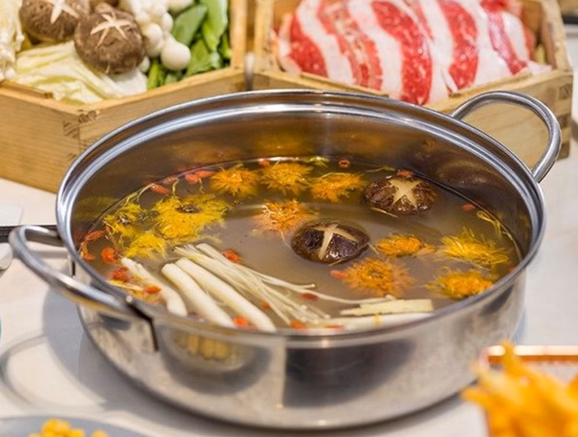 Nước dùng thường được hầm từ xương ống, gà ác và các loại nấm quý hiếm. Khi ăn, thực khách sẽ cảm nhận được vị ngọt thanh của hoa cúc hòa quyện cùng hương thơm đặc trưng của các loại nấm, tạo nên một dư vị khó quên. Ảnh: Dân Việt