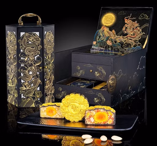 Bánh được thiết kế đựng trong hộp sơn mài lấy cảm hứng từ Hoàng gia. Từng chiếc bánh có lớp vỏ màu đen và phủ lên một lớp bột vàng óng ánh. Phần nhân được làm từ những nguyên liệu cao cấp như bào ngư và hải sâm thượng hạng, cua bát bửu, tôm bách hoa, hạt sen tứ quý, Sò Điệp Sốt X.O...Ảnh: Kinhdo.