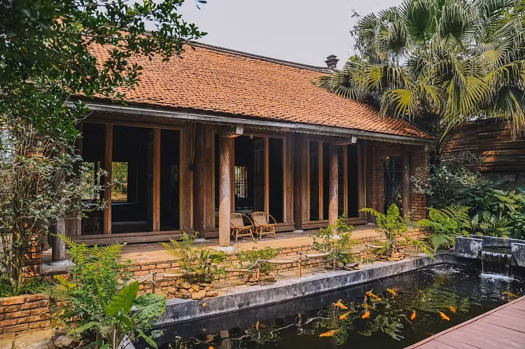 Công trình gồm 2 hạng mục là nhà sàn và nhà 3 gian. Phía trước nhà 3 gian có bể cá Koi đẹp mắt. Ảnh: Thanh Nhan Dang.