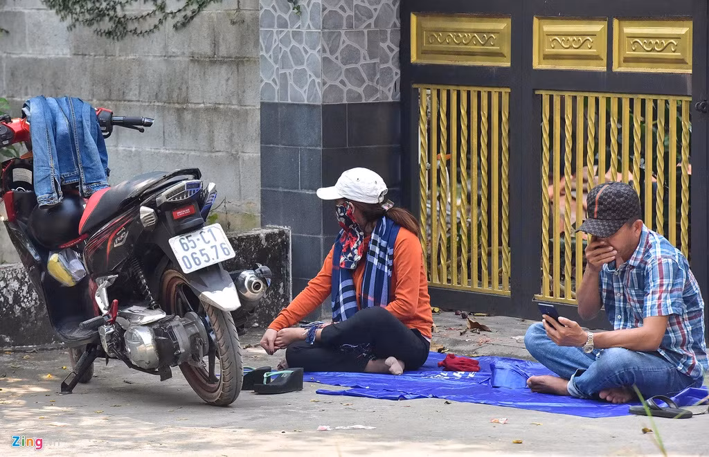Hàng trăm người đội nắng đứng theo dõi từ xa, quay điện thoại. Có nhóm còn dùng cả nylon trải chỗ mát gần khu vực vây bắt nằm nghỉ.