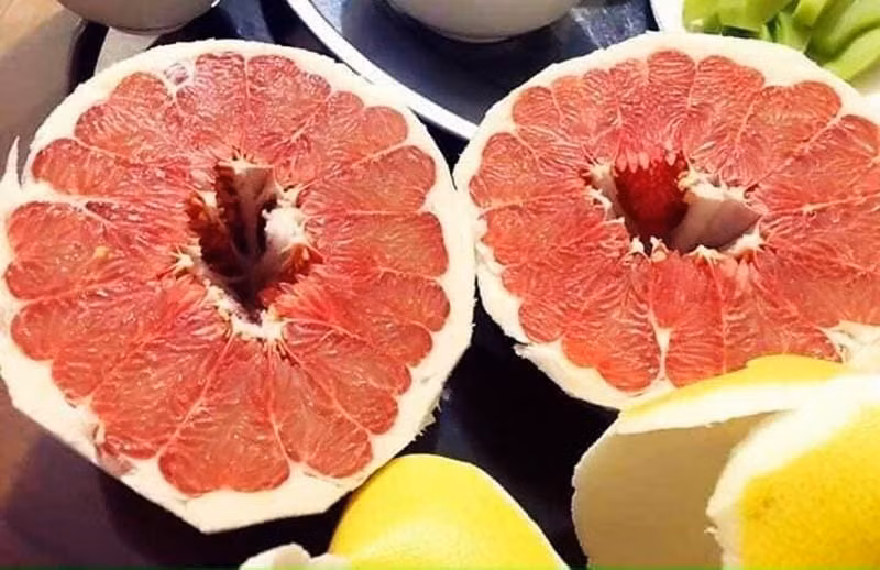 Vài tuần gần đây, bưởi được bày bán nhiều tại các khu chợ ở Hà Nội và "chợ mạng". Bên cạnh các loại bưởi trong nước như bưởi Phúc Trạch, bưởi Tân Lạc, bưởi Năm Roi, bưởi Hoàng… trên thị trường những ngày này còn xuất hiện loại bưởi có vỏ vàng óng vô cùng bắt mắt, phần ruột đỏ au. Ảnh: Vietnamnet.
