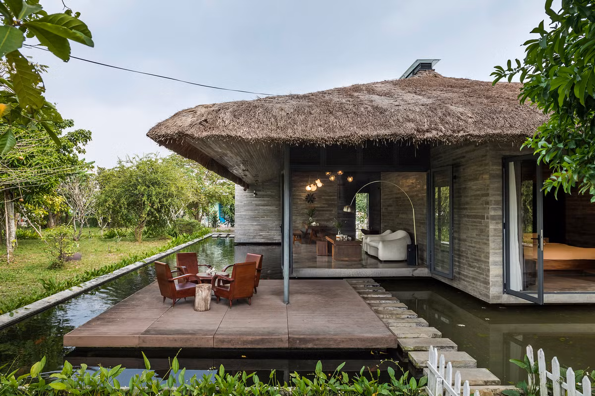 Căn nhà được thiết kế với 5 khối riêng biệt, bố trí ngẫu nhiên dưới một mái tranh lớn và ngay bên cạnh một hồ nước.