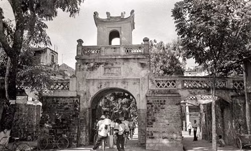 Ông John Ramsden đã đến và sinh sống ở Việt Nam những năm 1980 – 1983 khi đảm nhiệm vị trí Phó đại sứ Anh tại Hà Nội. Trong thời gian ở đây, nhà ngoại giao này đã chụp được hơn 1.800 bức ảnh về thủ đô Hà Nội cũng như cuộc sống của người dân ở mảnh đất ngàn năm văn hiến. Trong ảnh là cửa Ô Quan Chưởng ở đầu phố Hàng Chiếu sầm uất người qua lại.