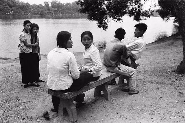 Một nhóm thanh niên ngồi trò chuyện ven hồ.