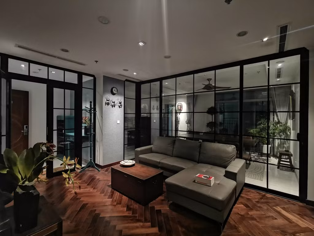 Bên cạch lót gỗ tự nhiên walnut, từ phòng khách còn có thể nhìn ra toàn bộ không gian của căn hộ qua vách ngăn phòng bằng hệ nhôm tạo cảm giác ấm cúng cho các thành viên trong gia đình.