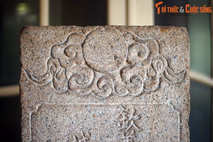 Tấm bia được tạc từ đá nguyên khối, cao hơn 1 mét, trang trí đơn giản với hình tượng mây và mặt trời ở trán bia.