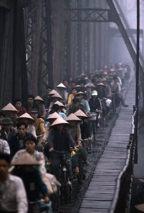 Dòng người đổ về nội thành Hà Nội vào buổi sáng trên cầu Long Biên, 1996. Ở Việt Nam cuối thập niên 1990, xe đạp vẫn là phương tiện đi lại phổ biến của người dân. Ảnh: Hiroji Kubota/ Magnum Photos.