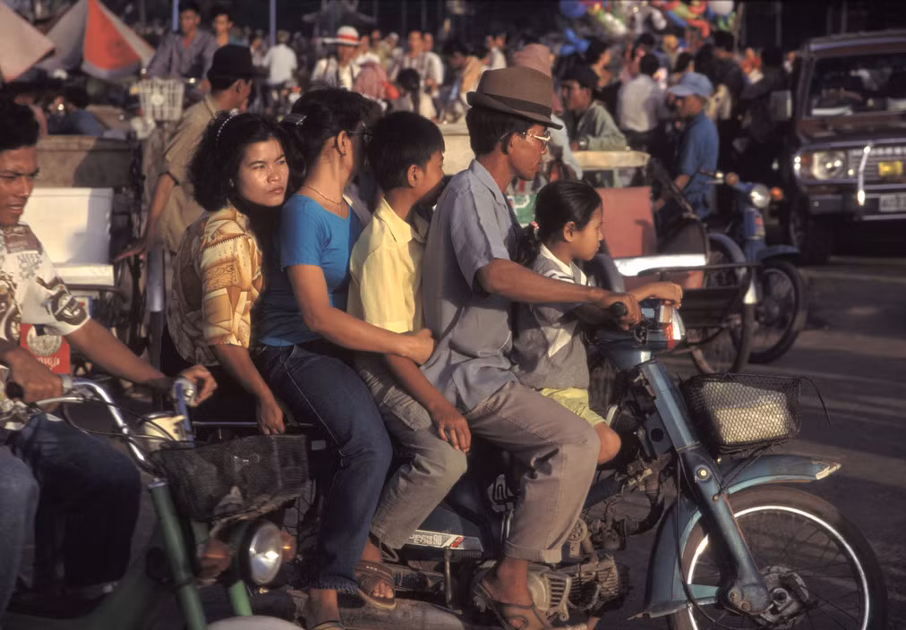 Một gia đình 5 người di chuyển bằng xe máy ở Phnom Penh năm 1994. Cũng như ở Việt Nam, xe máy là phương tiện di chuyển chính của người dân Campuchia thập niên 1990. Ảnh: Hiroji Kubota/ Magnum Photos.