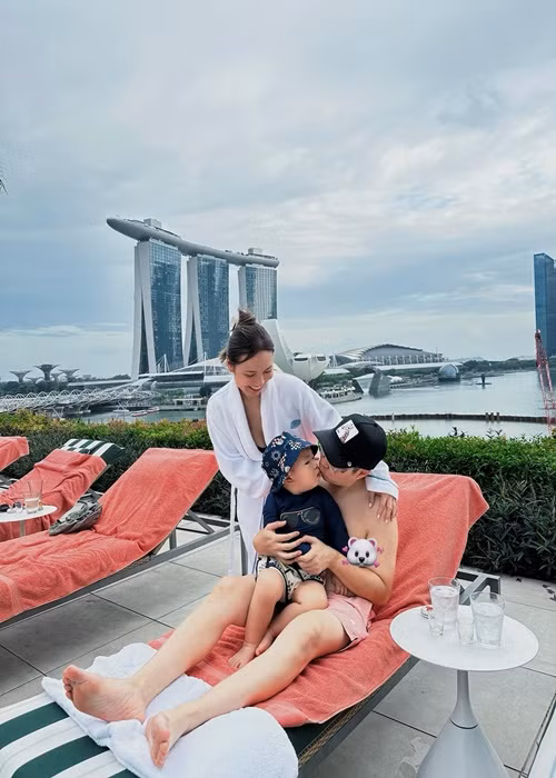Nam ca sĩ hôn con trai bên bể bơi trong chuyến du lịch.