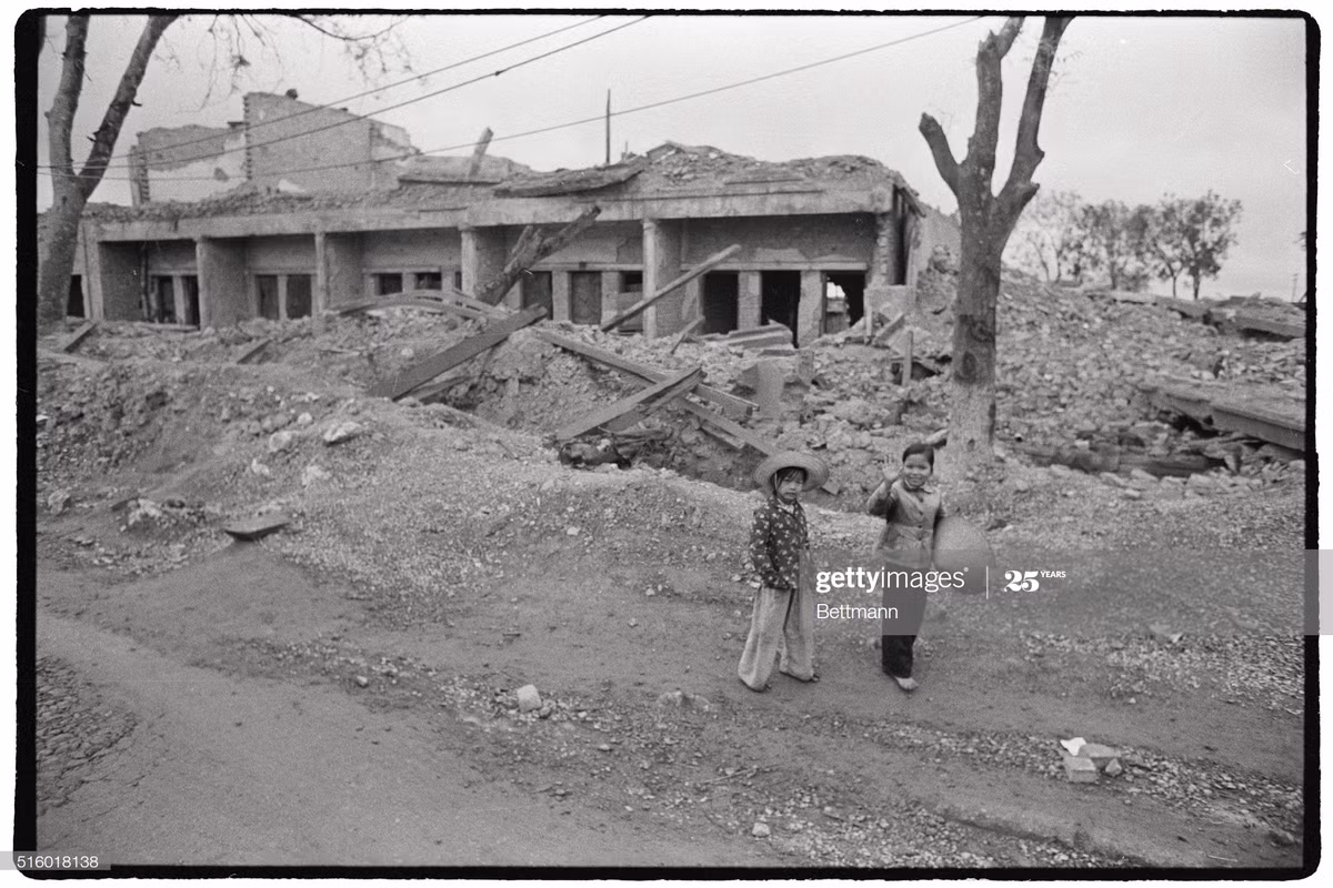 Hai em bé đứng gần một khu nhà đổ nát ở Hà Nội ngày 1/1/1973. Các cuộc ném bom vừa chấm dứt một ngày trước đó.