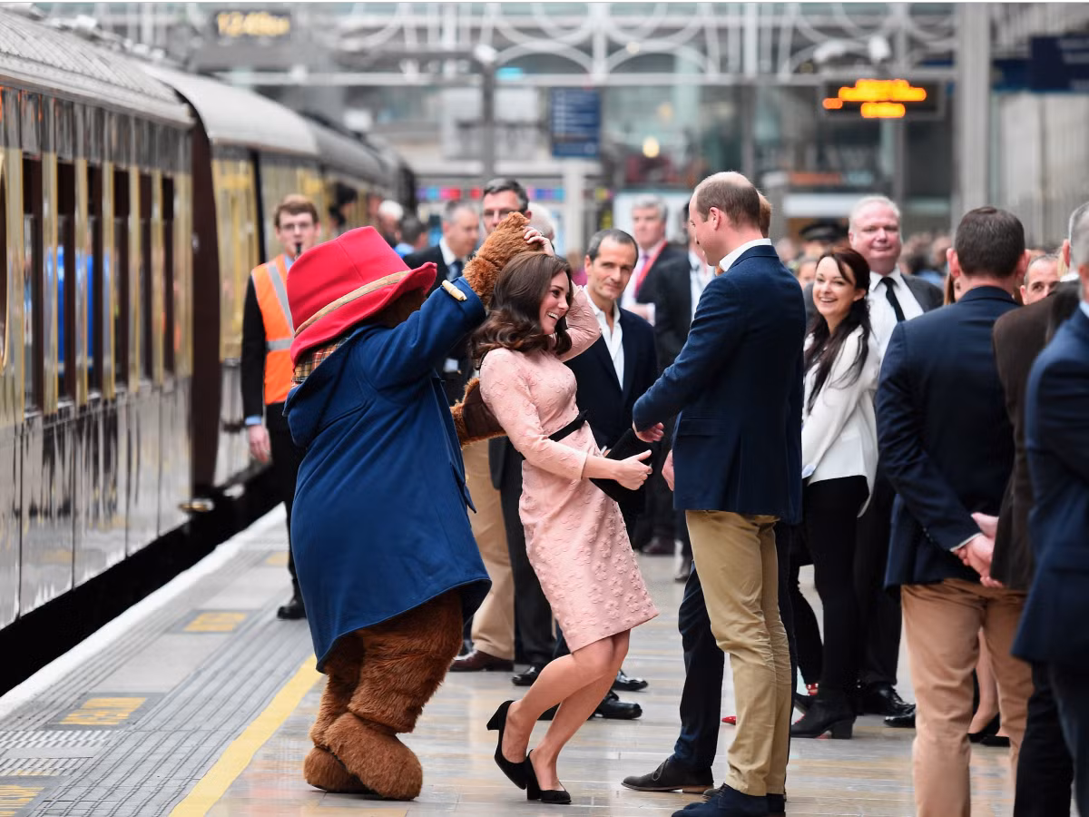 Công nương Kate cùng chồng có mặt tại sự kiện từ thiện ngày16/10, tổ chức ở sân ga Paddington, London. Hình ảnh công nương Kate rạng rỡ trong bộ đầm màu hồng pastel khiến mọi người bất ngờ khi ngẫu hứng nhảy cùng người đóng giả nhân vật hoạt hình Paddington.