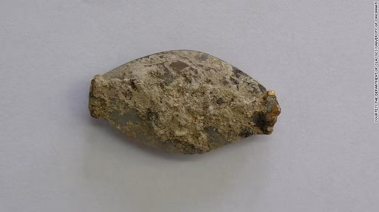 Con dấu bằng đá quý có chiều dài gần 3,6 cm bị bao phủ trong lớp đất đá trước khi được làm sạch.