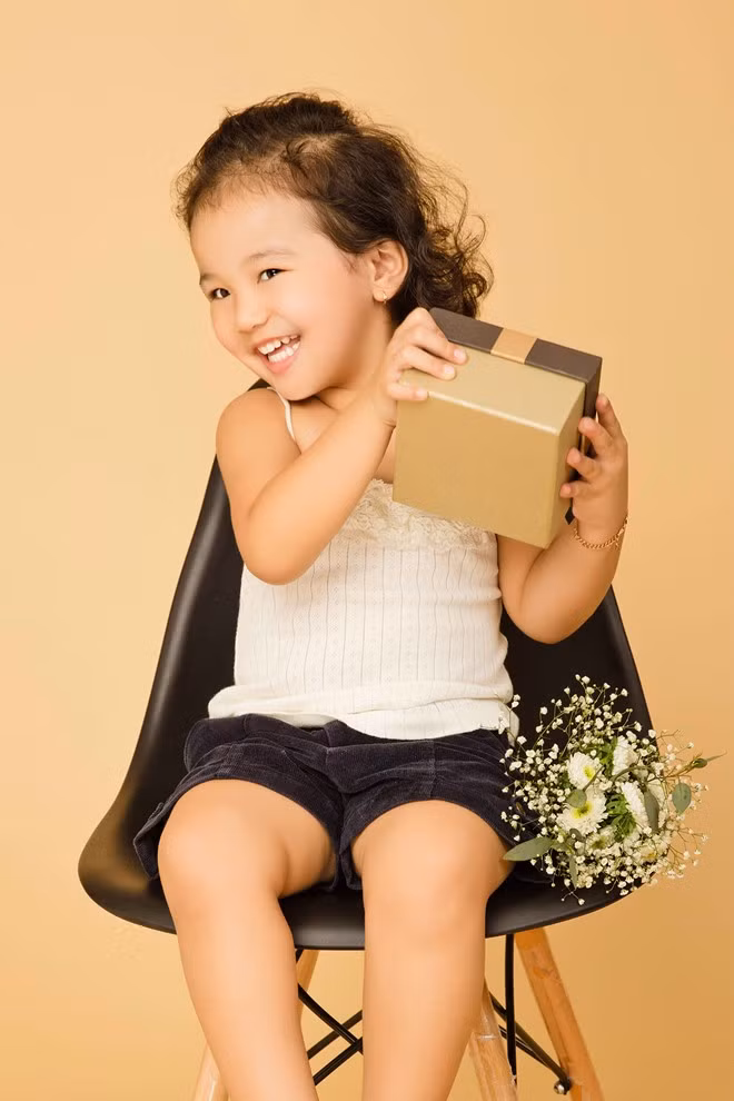Bé Na tinh nghịch khi chụp ảnh. Con gái thứ hai của hoa hậu được nhận xét là thừa hưởng nét đẹp từ bố lẫn mẹ. Bé khá nghịch ngợm và hiếu động trong suốt thời gian chụp ảnh.