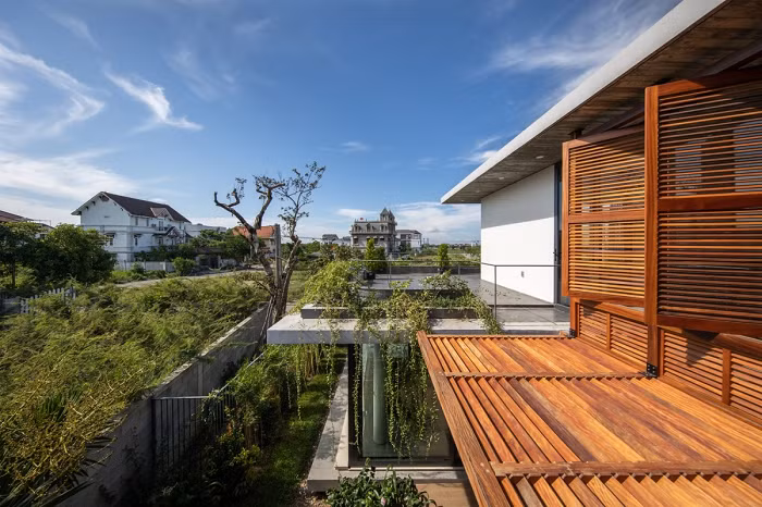 Hệ thống cây xanh trong nhà kết hợp mái bê tông có độ vươn lớn và hệ lam gỗ bảo vệ ngôi nhà khỏi tác động xấu của thiên nhiên.