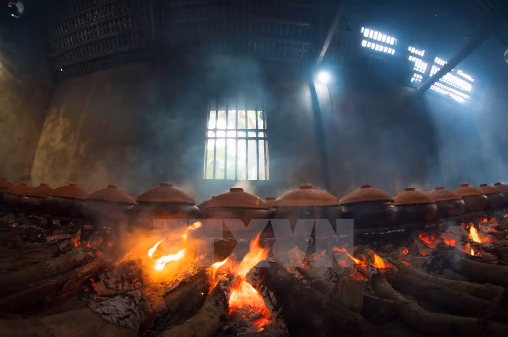 Cá được kho theo phương thức cổ truyền: kho bằng niêu đất trên bếp củi suốt 10 tiếng đồng hồ để cá mềm và thấm, có thể ăn được cả xương. Niêu cá kho một lửa suốt thời gian dài nên luôn phải có người canh bếp. Lửa không được để lớn ngọn và lúc nào than cũng phải đỏ. (Ảnh: Trọng Đạt/TTXVN)