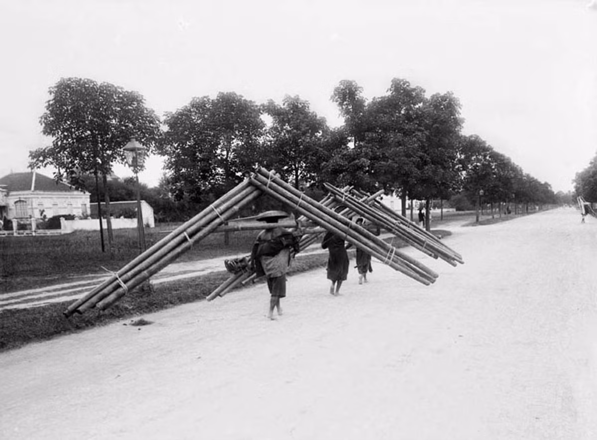 Phụ nữ địa phương gánh tre trước nhà vợ chồng ông Imbert ở Hà Nội, 1906.