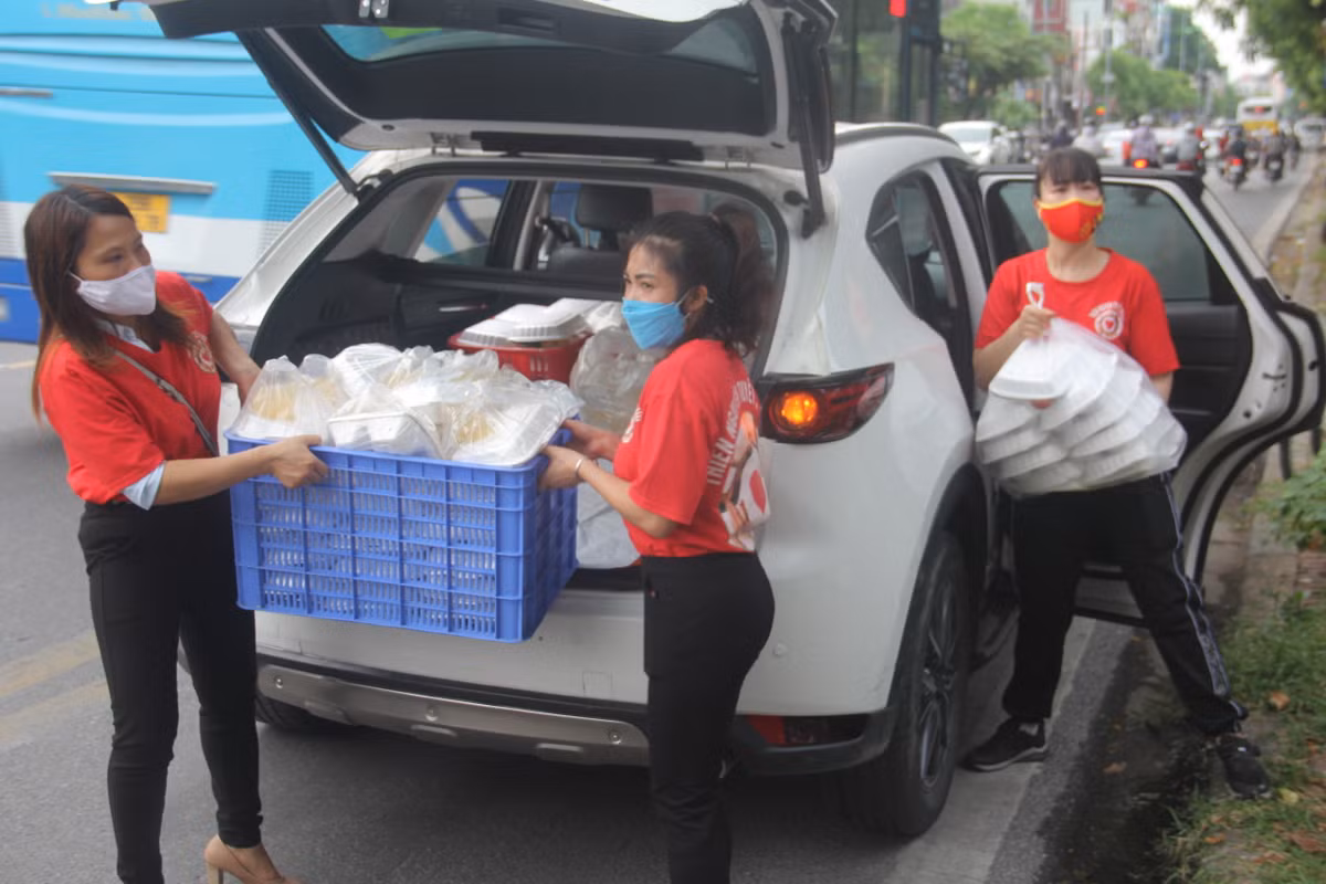 Tình nguyện viên mang theo những suất cơm đến các địa điểm để chuẩn bị phát cho người khó khăn.