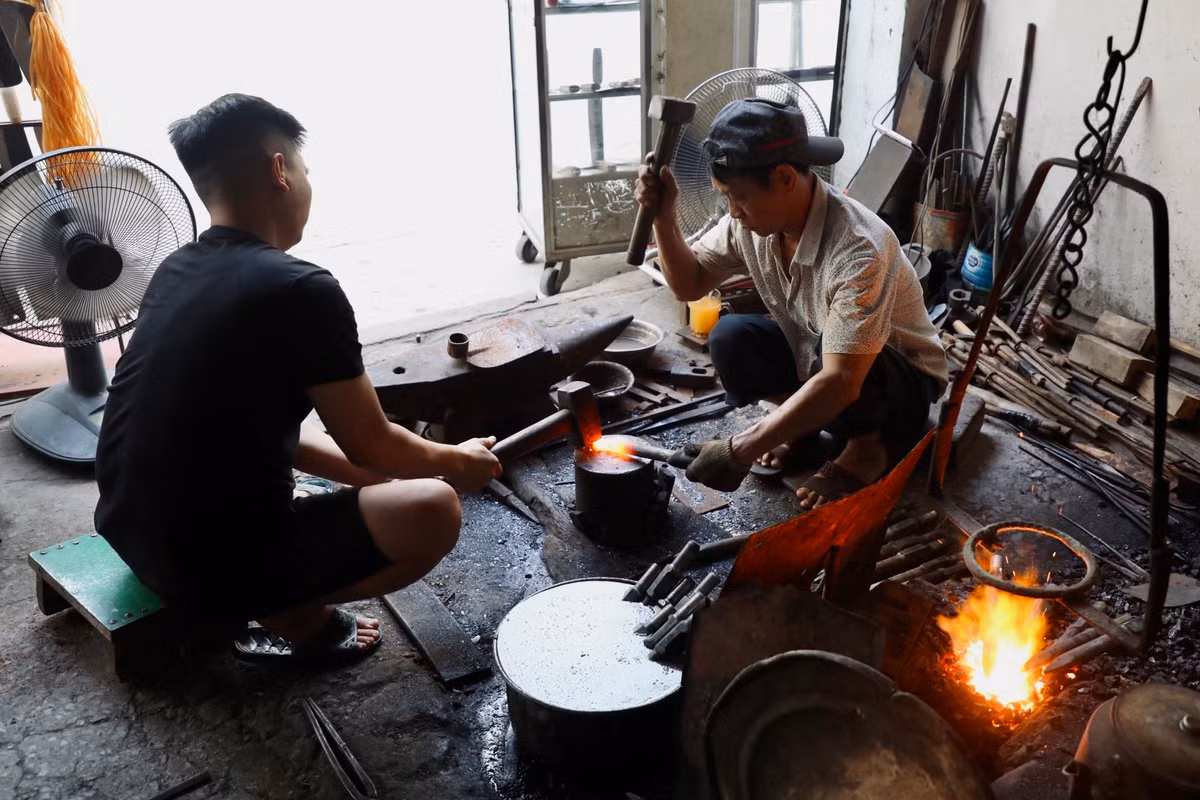 Phụ nghề cho ông Cung còn có vợ và con trai, dù không theo nghề của cha, nhưng khi rảnh rỗi anh Đạt đều xắn tay phụ giúp. Để rèn một sản phẩm cần có hai người thợ, một người gõ nhịp dẫn và một người để quai. Những tiếng gõ chan chát vào miếng sắt đỏ lửa nhịp nhàng, ăn ý sẽ cho sản phẩm tốt và đảm bảo an toàn lao động.