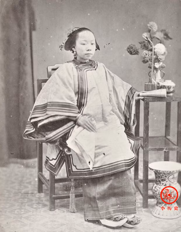 Một phụ nữ người Khách Gia (hay còn gọi là người Hẹ). Tay trái của cô đang cầm một quyển sách, đây là tư thế quen thuộc khi chụp ảnh trong phòng chụp ảnh cuối thời nhà Thanh.
